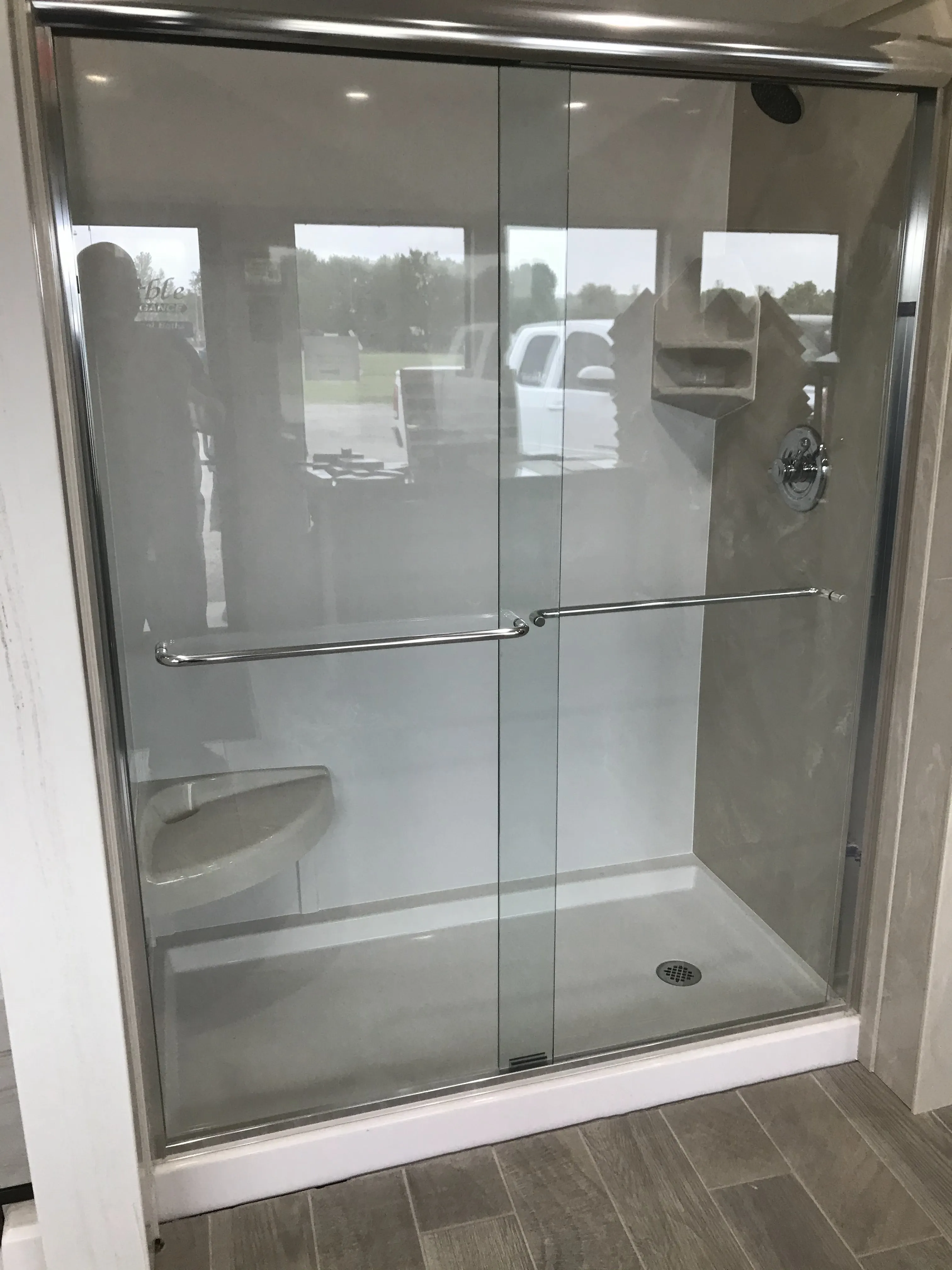 A glass shower enclosure with a chrome frame and towel bar