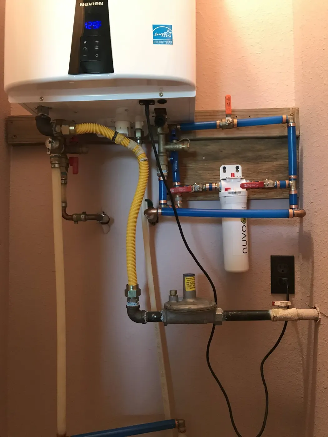 A wall-mounted tankless water heater with new gas, water and filter connections